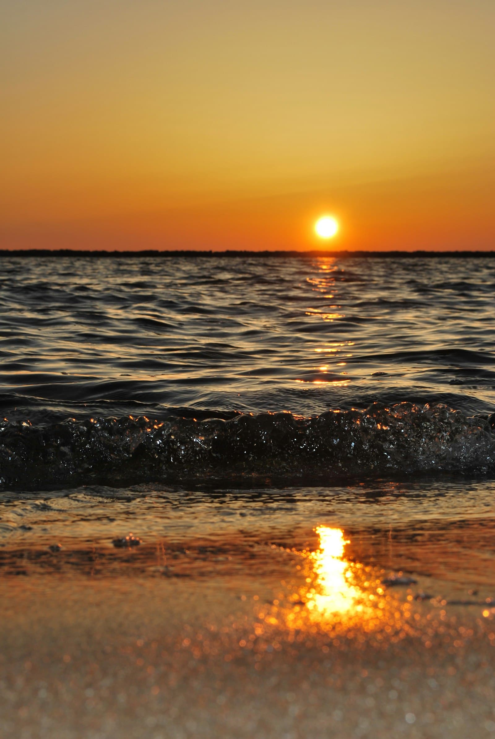 Wave breaking on the shore at sunset